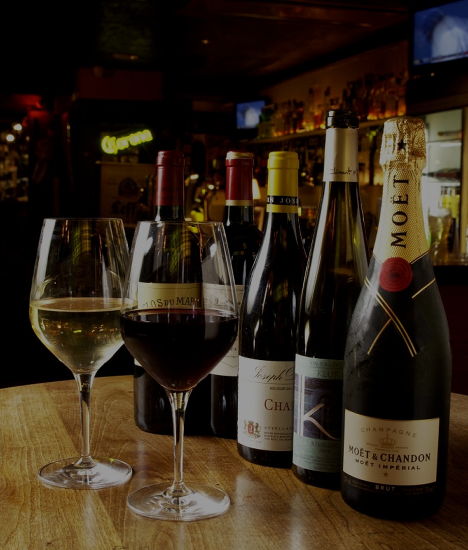 ワインやシャンパンのボトルとグラスに注がれたワイン